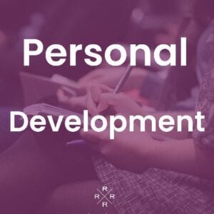 A person writing on paper with the words personal development in front of them.